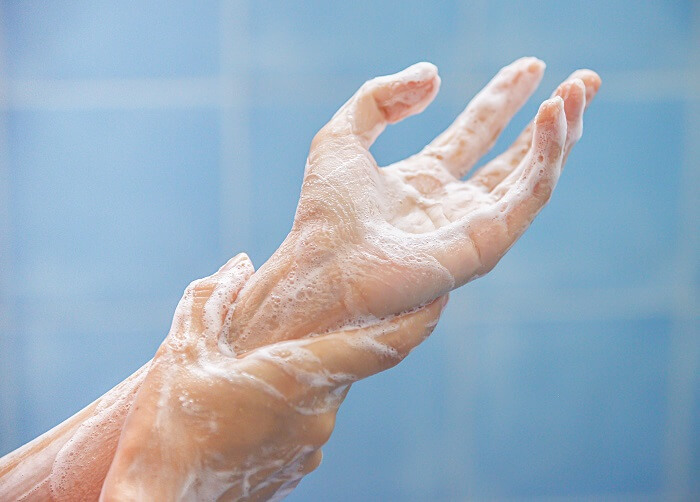 Zwei Hände schäumen sich gegenseitig mit Seife ein.